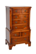 A reproduction yew veneered miniature chest on chest in the Georgian style - the moulded top over