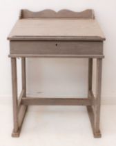 A 19th century painted pine clerk’s or school desk: the shaped gallery back over a bookrest fall,
