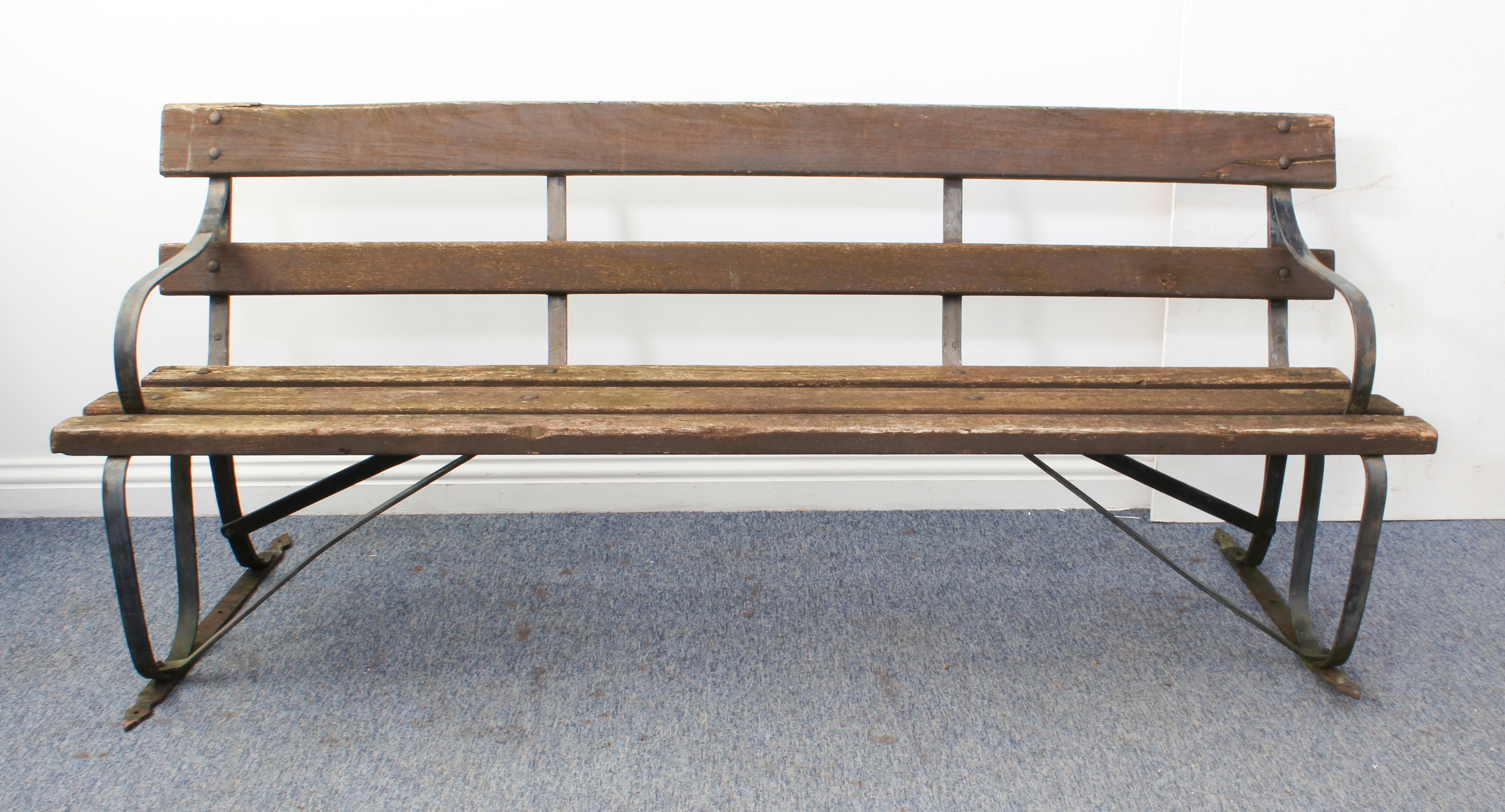 A wrought iron and hardwood slatted garden bench - 198 cm long. (similar to lot 549)