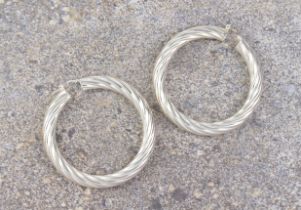 A large pair of silver hoop earrings