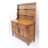 An Ercol Windsor elm dresser - the back with waterfall plate rack, over a base with two drawers (one