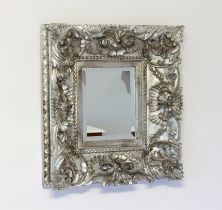 An antique style silvered mirror - the moulded composite frame with foliate decoration, around a