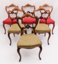 A set of six Victorian walnut dining chairs - the shaped, waisted backs with carved foliate