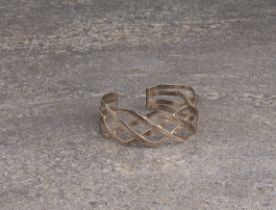 A sterling silver interlaced lattice style bangle - stamped '925', internal size 6.4 x 5.2 cm.