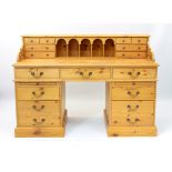 A large pine double pedestal desk - the raised gallery back with five arched pigeonholes flanked