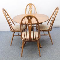 An Ercol Windsor elm extending dining table and four swan-back Windsor dining chairs - the table