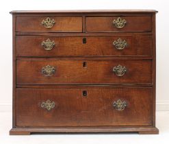 A George III oak straight-front chest of drawers - the moulded top over two short and three long