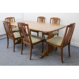 An Ercol Windsor elm dining table - the slightly rounded rectangular top on shaped trestle end-