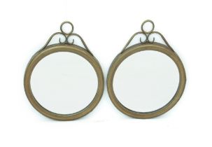 A pair of circular antique gold finished metal mirrors - modern, with open scrollwork surmounts with