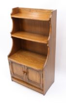 An Ercol Windsor elm waterfall bookcase - with Ercol label to reverse, with three graduated