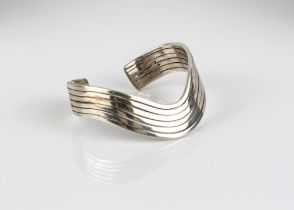 A modernist style silver bangle - stamped 'Mexico 925', of pierced, six-row wave design, internal