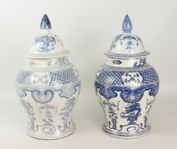 A matched pair of Chinese blue and white porcelain covered baluster vases - painted with dragons,