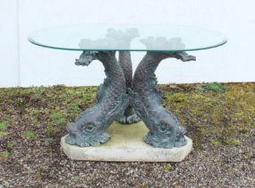 A glass-topped conservatory or garden table - the triform carp or stylised dolphin supports in