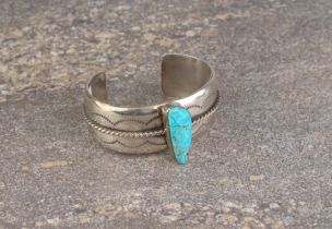 A silver and turquoise bangle - stamped 'b. Ashley Sterling', the broad, slightly domed bangle