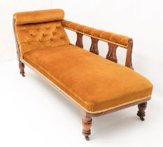 A late-Victorian oak chaise longue - with three pierced vase splats and carved showframe to the arm,