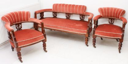 An Edwardian walnut three-piece parlour suite - comprising a two-seater sofa and a pair of tub