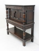 A 17th century style carved oak court cupboard - early 20th century, the plain top over a dentil and