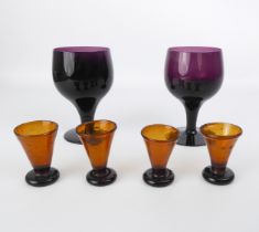 A pair of amethyst glass rummers - 20th century, 14.8 cm high; together with a set of four blown