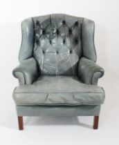 A blue-green buttoned leather Chesterfield style wingback armchair - the slightly arched buttoned