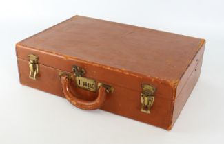 A vintage tan leather briefcase - hard shell, with brass hardware, the interior with nine filing