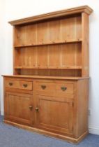 A Victorian waxed pine dresser - the flared, ogee moulded cornice over a closed, two-shelf back with