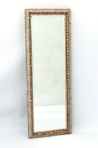 A modern long dressing mirror - bevelled plate, silvered wooden frame carved with stylised