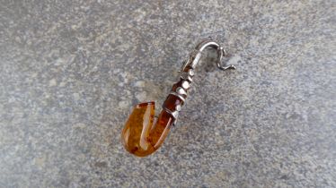 A sterling silver and amber saxophone brooch - stamped '925', 54mm long.