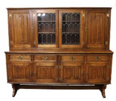 A reproduction oak low dresser in the 17th century style - the moulded and hobnail carved cornice