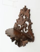 A Victorian carved and pierced oak wall bracket - carved with a bird eating berries from a scrolling