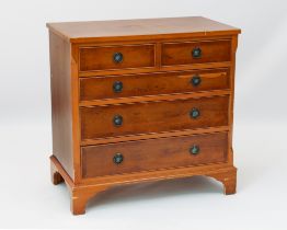 A reproduction Georgian style yew veneered chest of drawers - of small proportions, the cross-banded