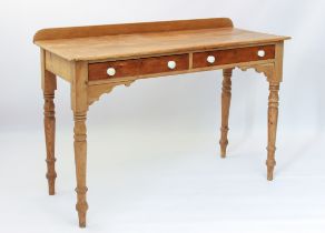 A Victorian waxed pine two-drawer side or writing table - the single piece top with short back and