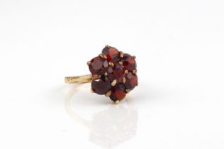 A 9ct rose gold and garnet cluster ring - stamped '9CT', with a floral cluster of seven round cut