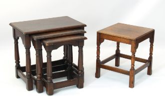 A reproduction nest of three oak tables - in the 18th century style, with turned gun barrel supports