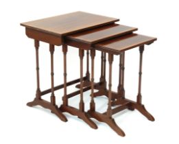 A reproduction Regency style cross-banded mahogany nest of three tables - the rectangular tops on