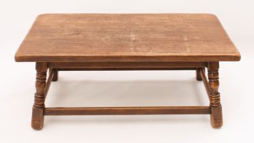 An antique style oak coffee table - mid-20th century, the rectangular top on four splayed,