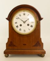 An Edwardian walnut cased mantel clock - the half hour striking, eight day twin train movement by