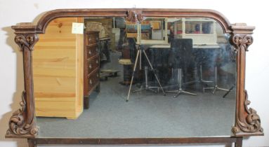 A large Victorian carved mahogany mirror - originally from a sideboard, the broken-arch moulded