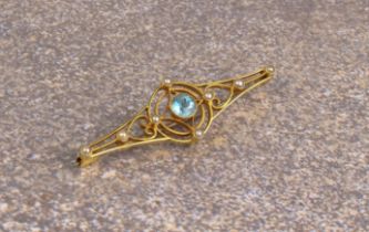 An Edwardian 15ct gold, aquamarine and seed pearl openwork bar brooch - stamped '15', 4.4 cm long.