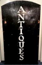 A vintage painted wooden 'Antiques' shop sign - black with vertical 'old style' white lettering,