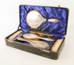 A cased George V silver-mounted dressing-table set - Birmingham 1924, comprising four brushes, a