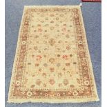 A small Zeigler wool rug - with floral decoration on a buff field, within a light brown floral