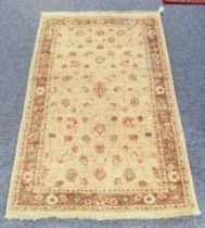 A small Zeigler wool rug - with floral decoration on a buff field, within a light brown floral