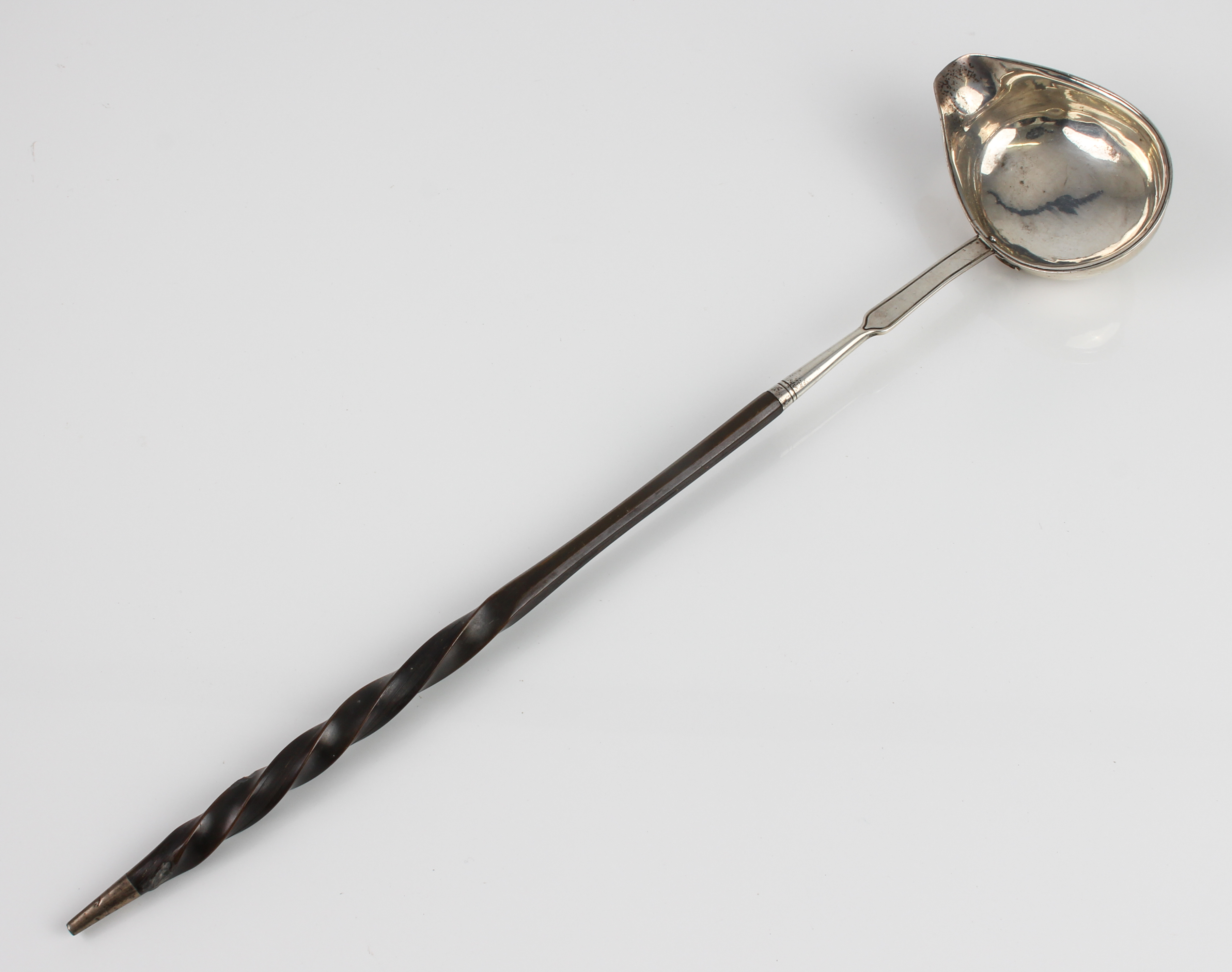 A 19th century white-metal toddy ladle - no marks, the oval bowl with side spout and engraved