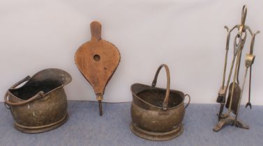 Two antique copper coal scuttles, a modern fireside companion set and a set of wood and leather