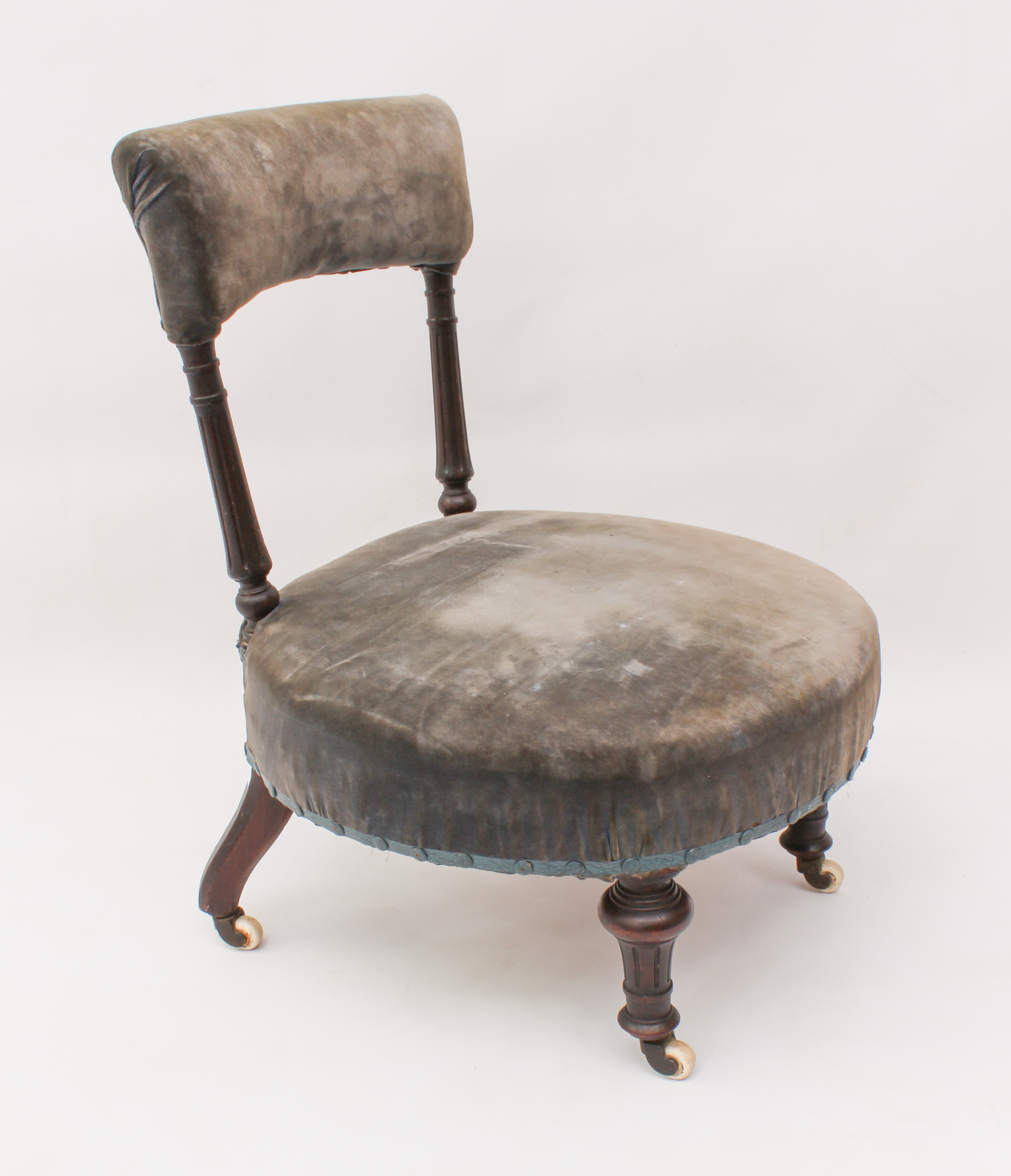 A Victorian walnut nursing chair - the padded top back on fluted turned uprights, over a circular