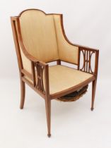 An Edwardian mahogany and satinwood open armchair in the Sheraton revival taste - the angular back