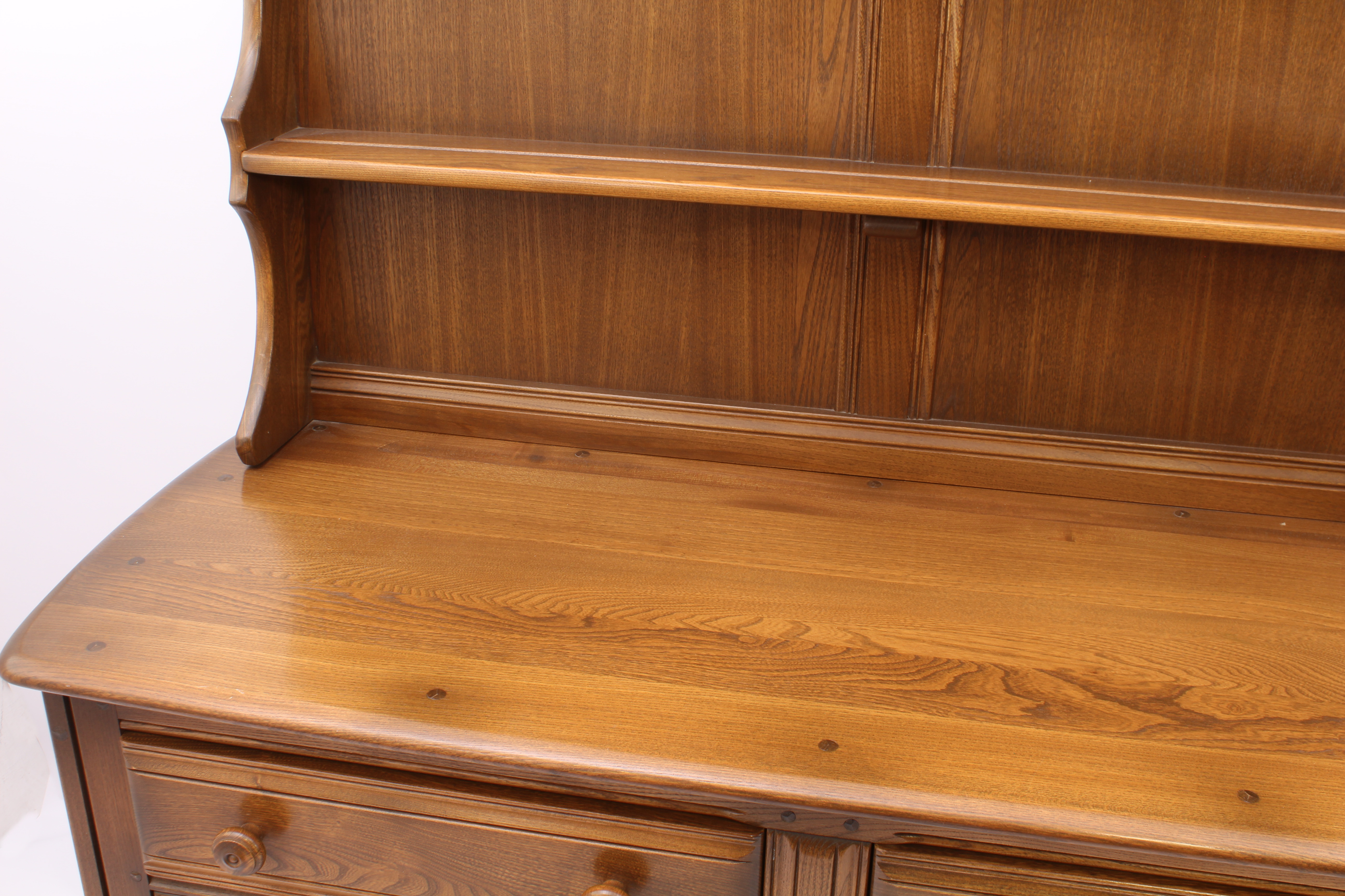 An Ercol Windsor elm dresser - the back with waterfall plate rack, over a base with two drawers (one - Image 4 of 8