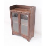 Two pieces: a small 1930s oak glazed bookcase - with open shelf top over a pair of glazed doors
