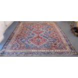 A large Persian Heriz rug - probably early 20th century, the three madder pole medallions with