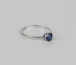 A 10ct white gold and sapphire solitaire ring - the 5.5 mm round cut sapphire in a four claw